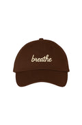 Front view of a brown dad hat featuring the embroidered "breathe" script in ivory.
