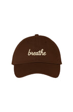 Front view of a brown dad hat featuring the embroidered "breathe" script in ivory.