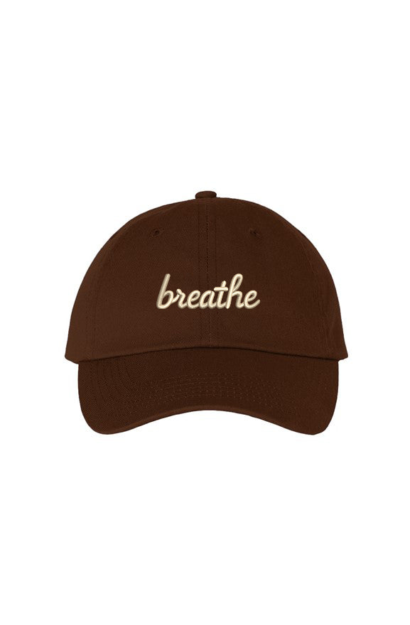 Front view of a brown dad hat featuring the embroidered "breathe" script in ivory.