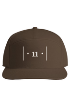 front view of a brown cap with white embroidered Passage Mark featuring vertical bars, dots, and the number 11