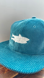 Angled view of a teal corduroy hat featuring ivory sardine embroidery