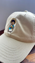 Angled view of a beige dad hat featuring the Light Guardian angel embroidery.